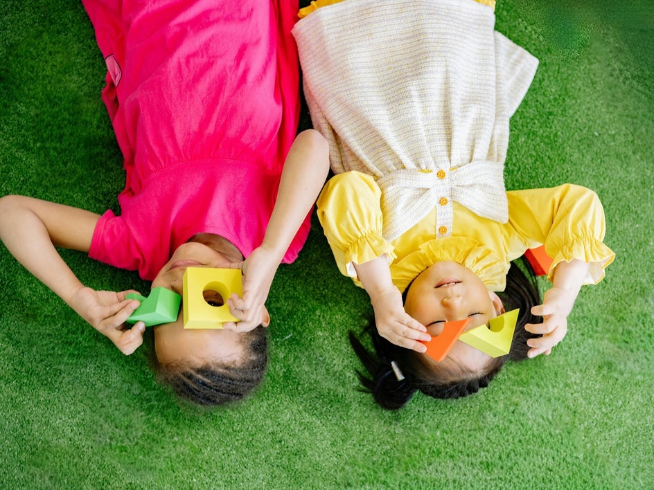After: Many toys have been digitally removed to emphasize the children and improve the visual balance.