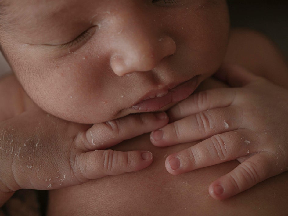 Before: Indoor newborn portrait with dark lighting and flaky skin before edits in BeFunky