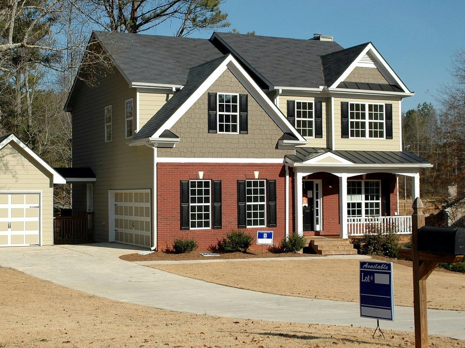 Before: A real estate exterior shot showing a house with sale sign on front lawn